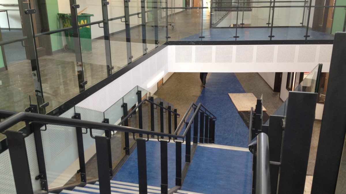 Glass balustrades around a stair with steel posts and handrails